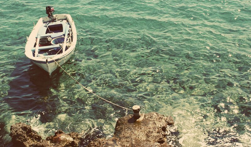 Small boat anchored in clear water