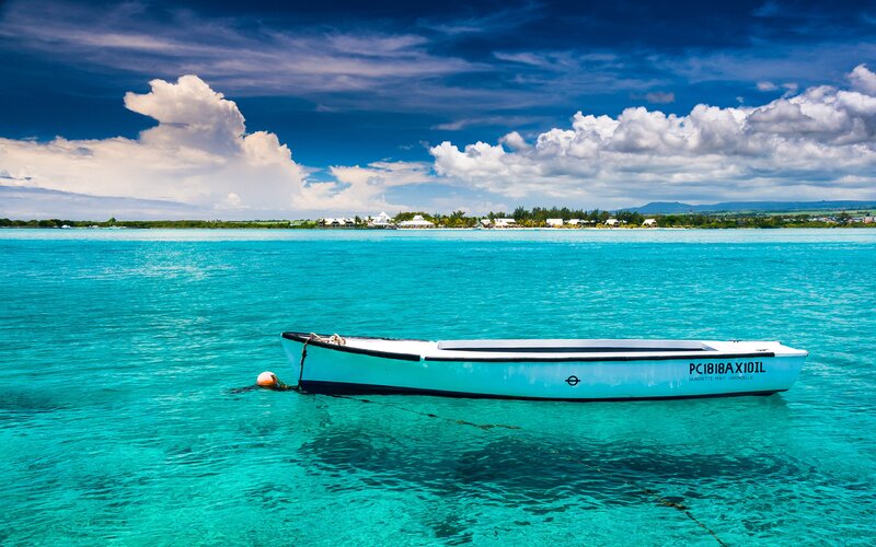 Small Boat in Turquoise Water — Blue, Serene, Afternoon, Photograph, Clouds