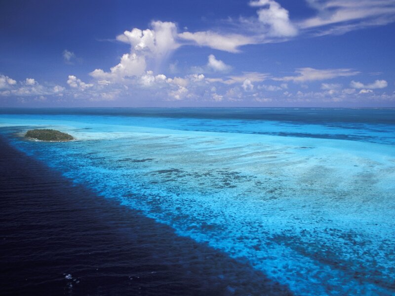 Small Island in Ocean — Blue, Serene, Afternoon, Photograph, Sky, Clouds