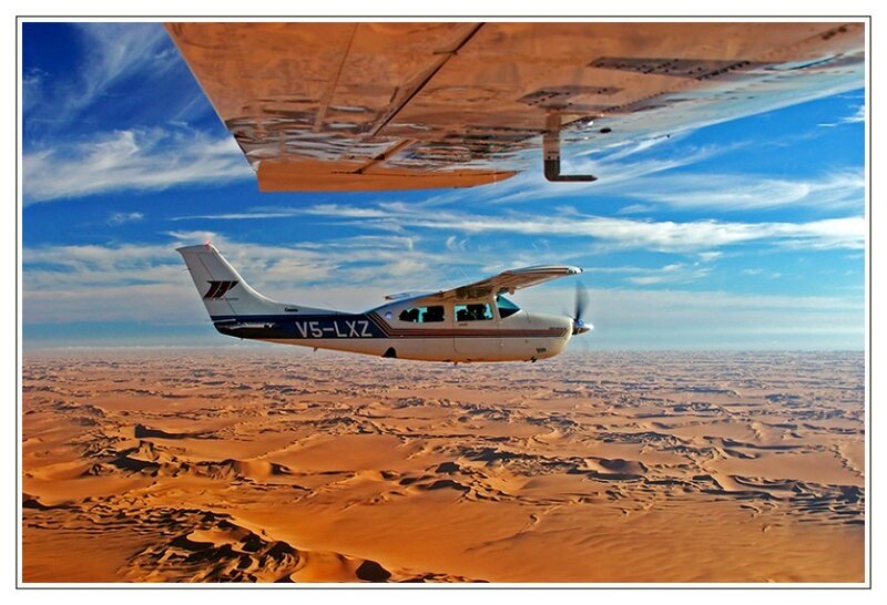 Small plane over desert dunes