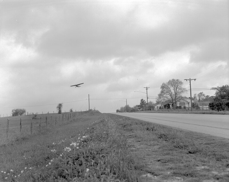Small plane over rural road
