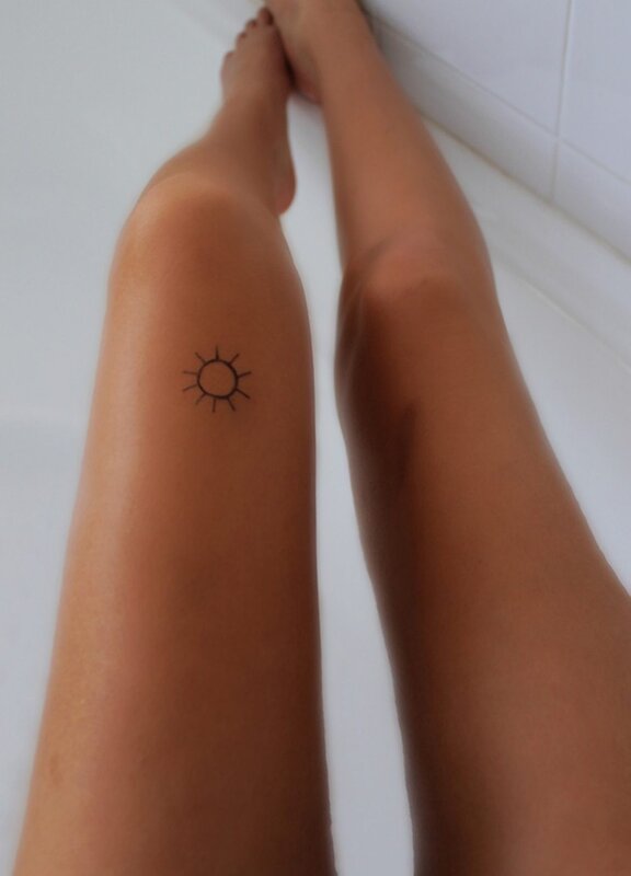small sun tattoo on leg