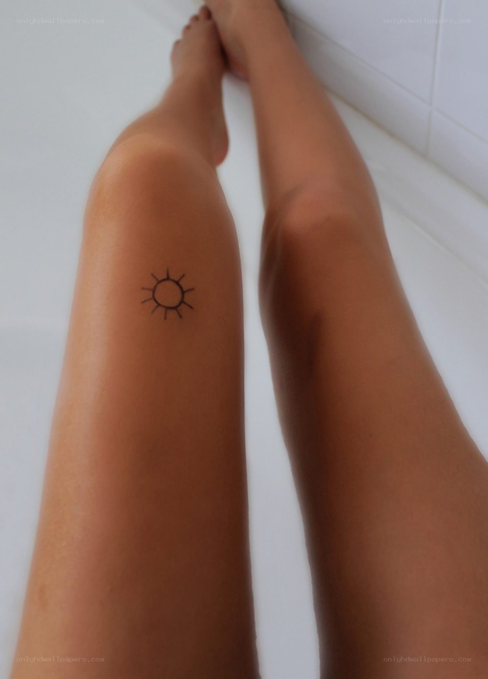 small sun tattoo on leg