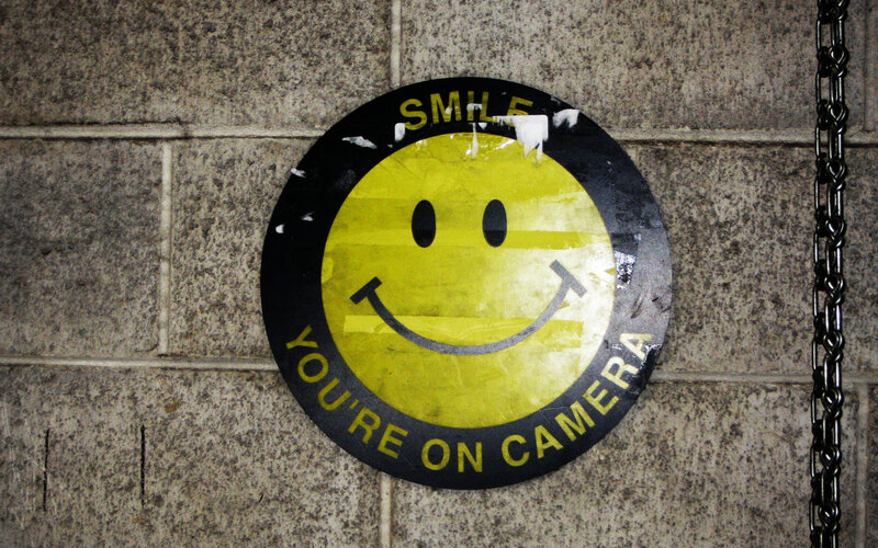Smiley face camera warning sign