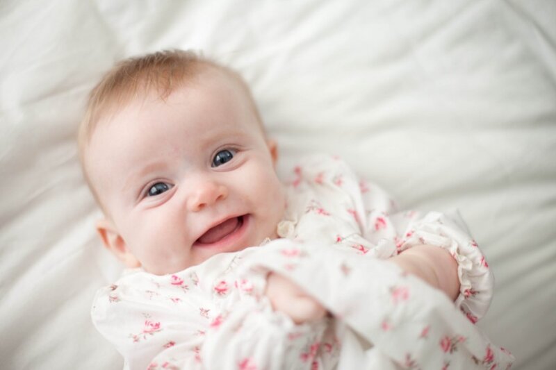 Smiling Baby in Floral Onesie