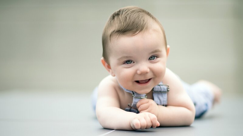 Smiling Baby Lying Down — Gray
