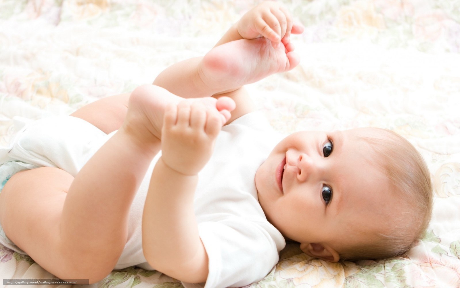 smiling baby lying on bed