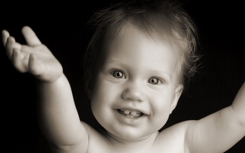smiling baby with raised arms