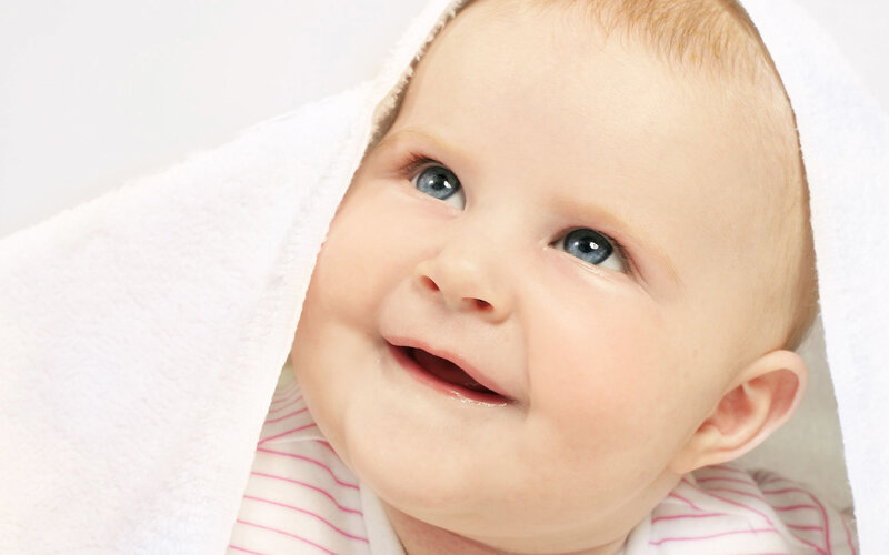 smiling baby wrapped in towel