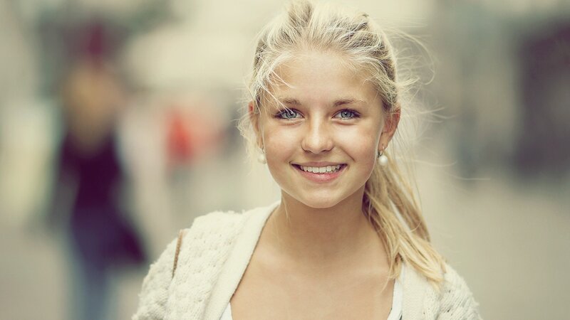 smiling blonde girl in street