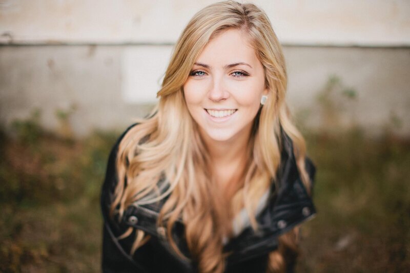 smiling blonde woman in leather jacket