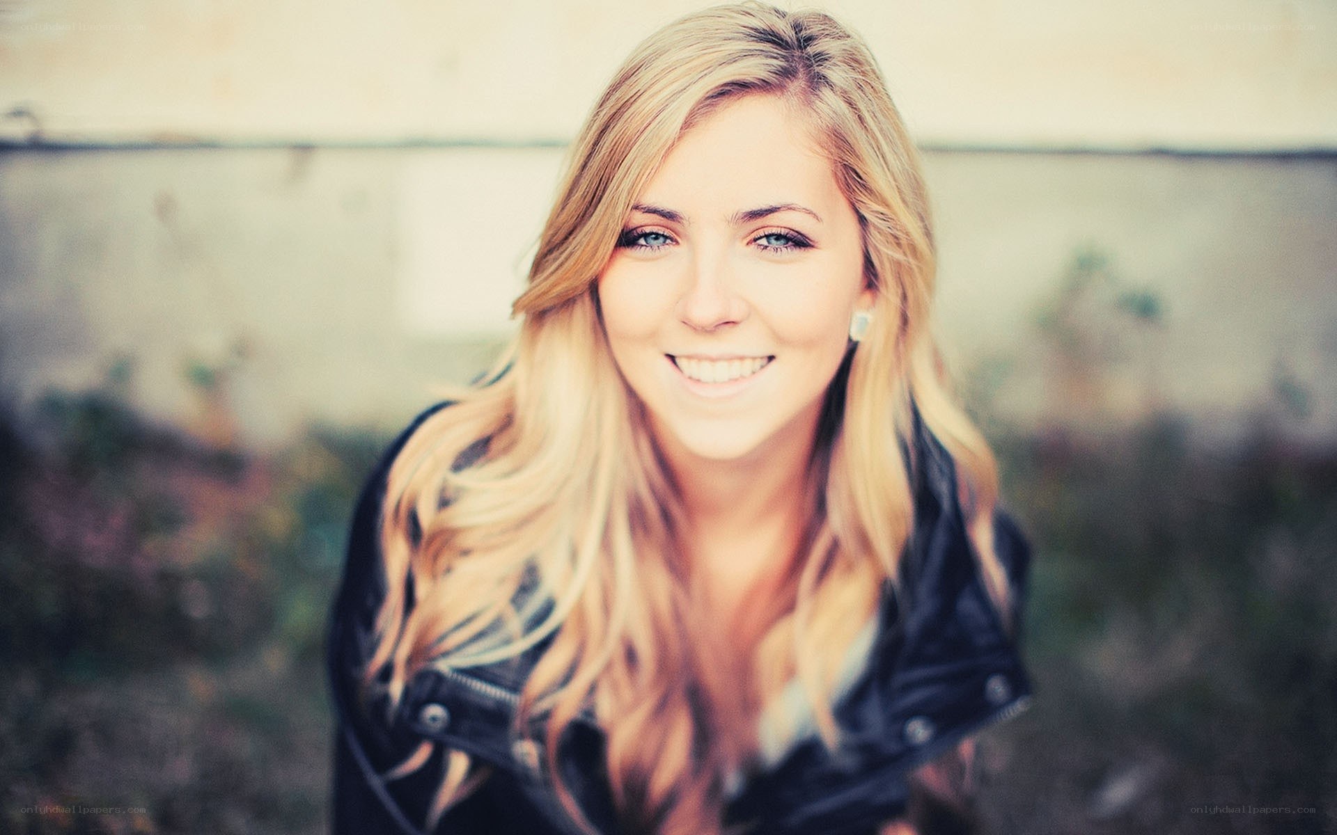 smiling blonde woman in leather jacket
