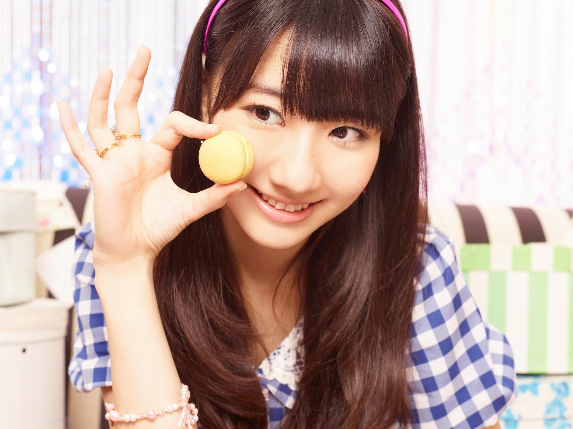Smiling girl holding a macaron
