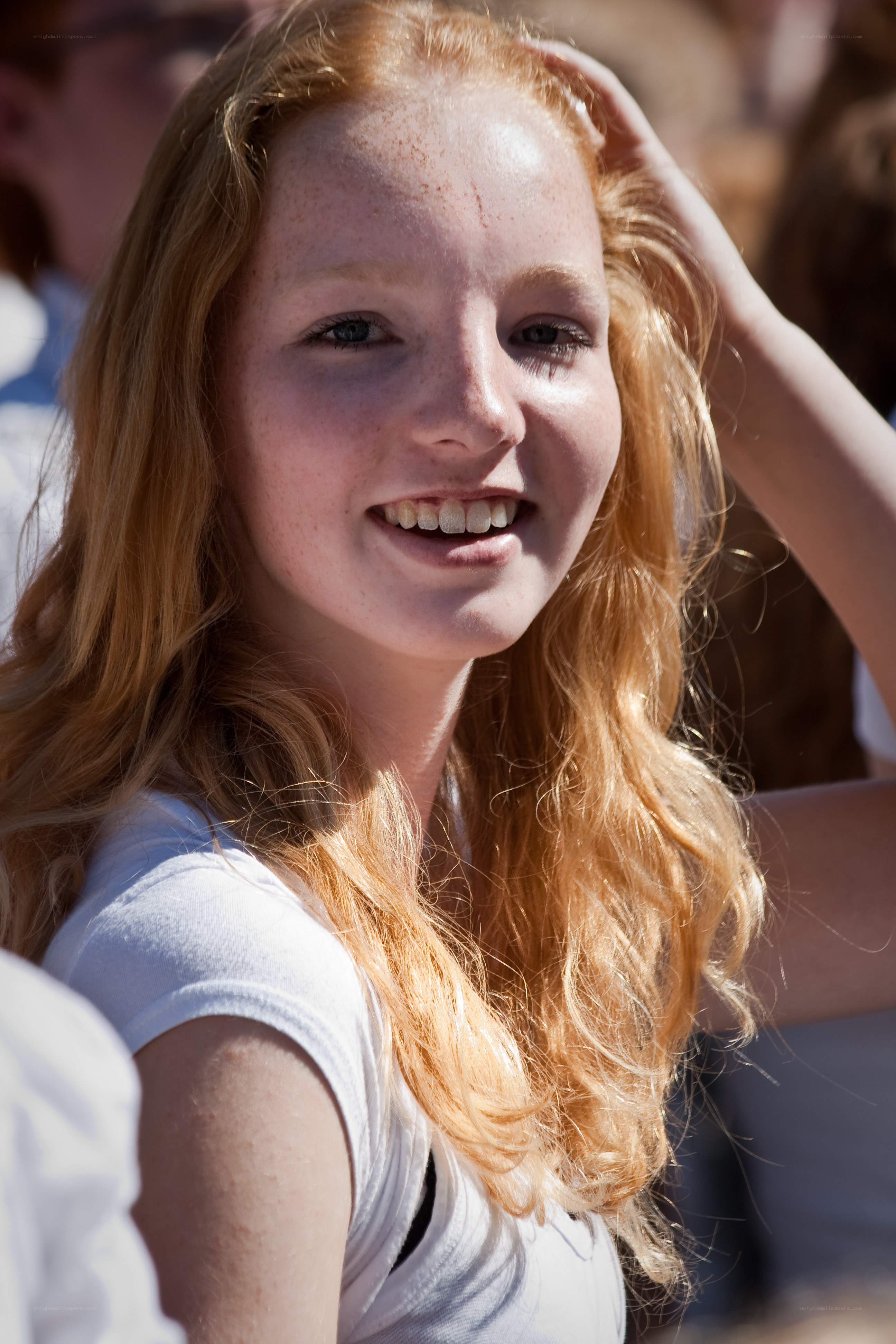 Smiling red-haired girl outdoors