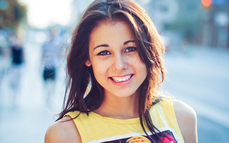smiling woman in yellow shirt