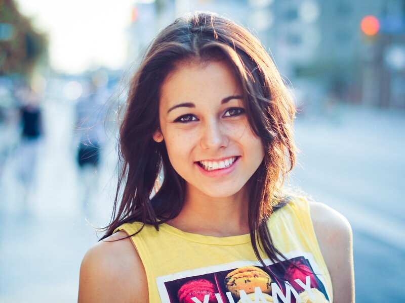 smiling woman in yellow shirt