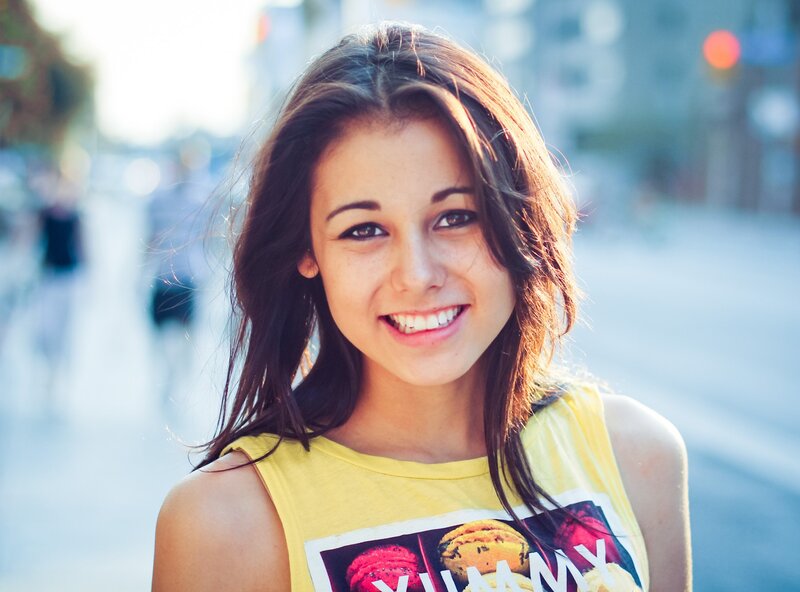 smiling woman in yellow shirt
