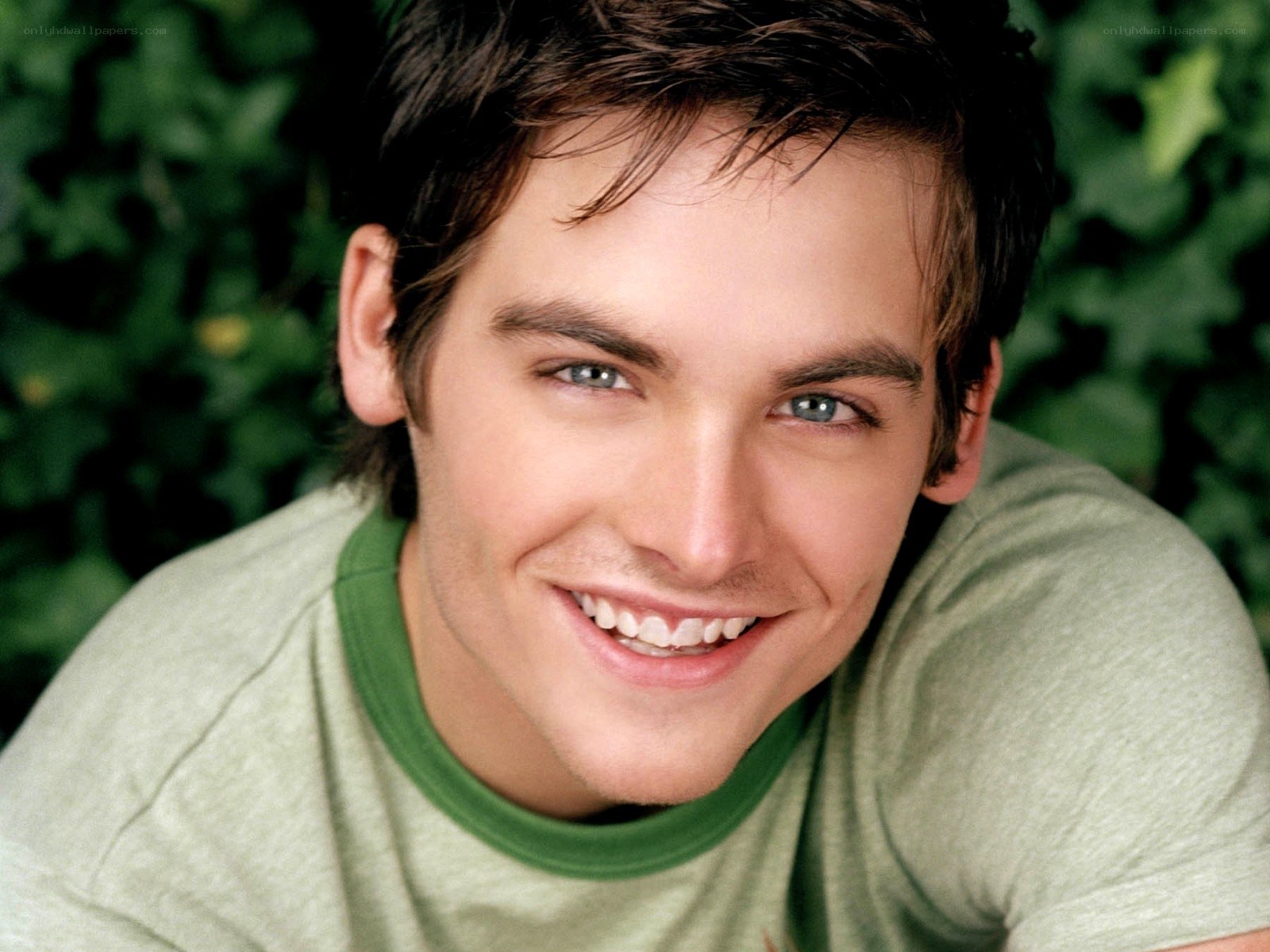 smiling young man in green shirt