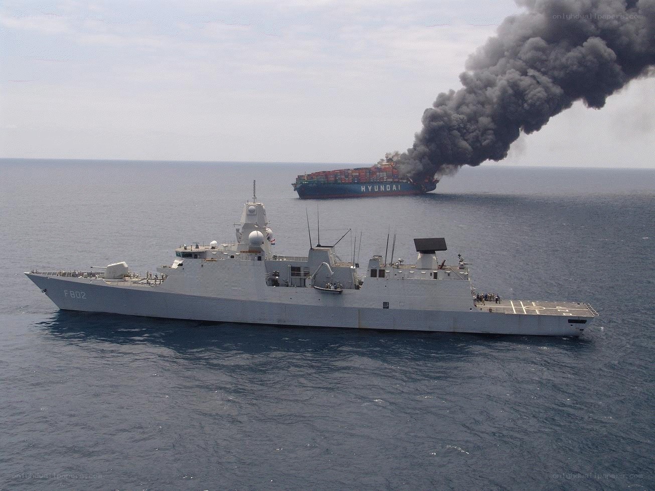 Smoking cargo ship at sea