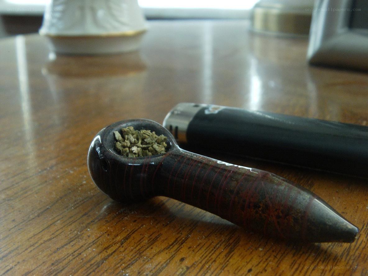 Smoking pipe and lighter on table