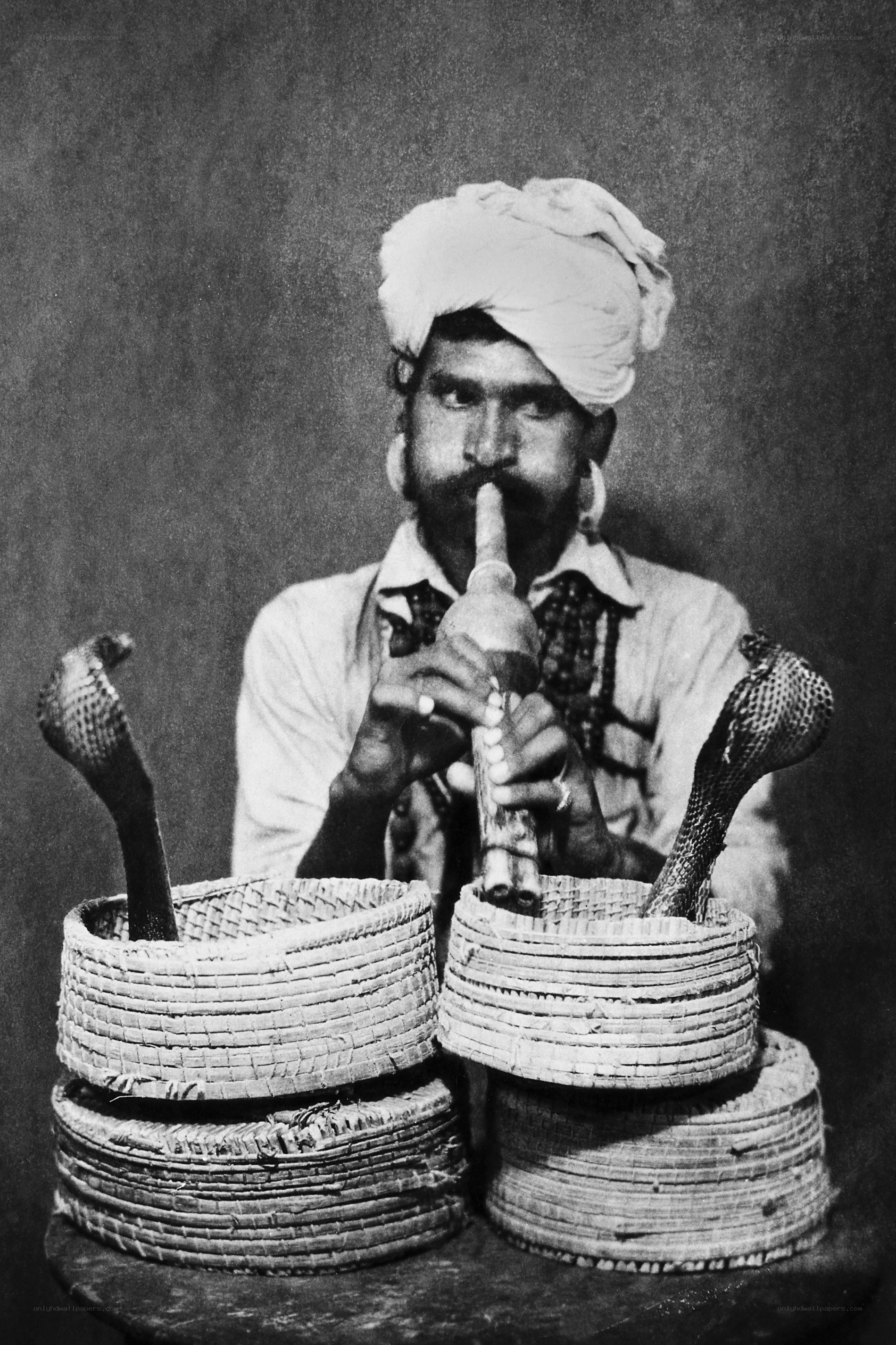 Snake charmer with cobra baskets