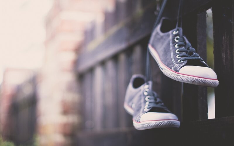 sneakers hanging on a fence