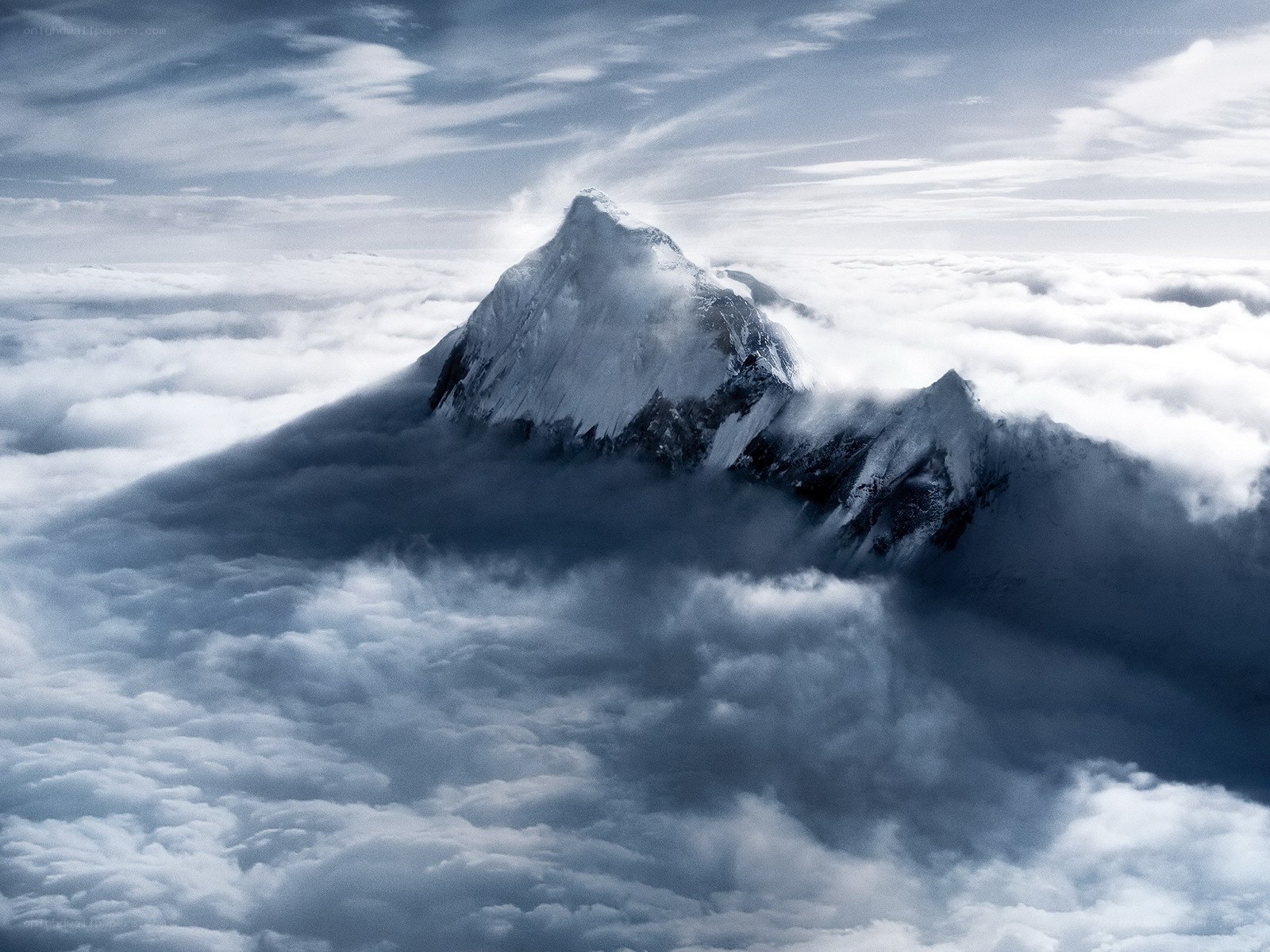 Snow-capped mountain above clouds