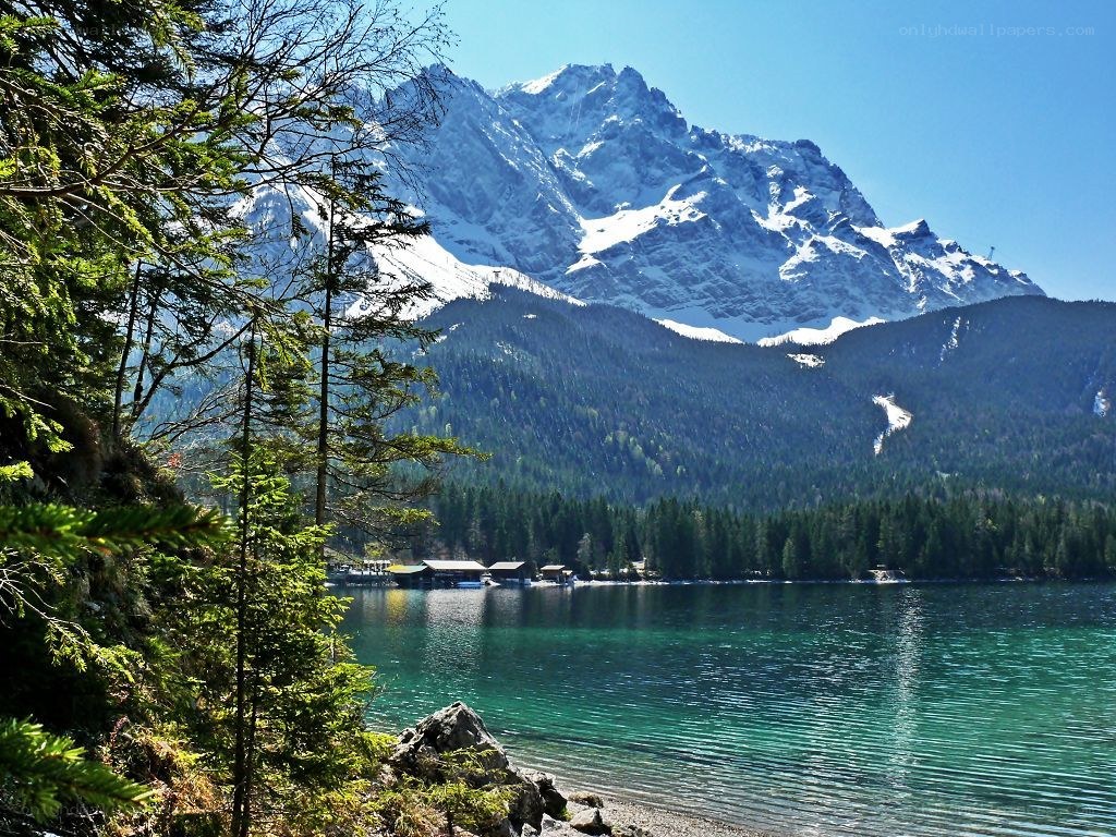 Snow-capped mountain by a turquoise lake