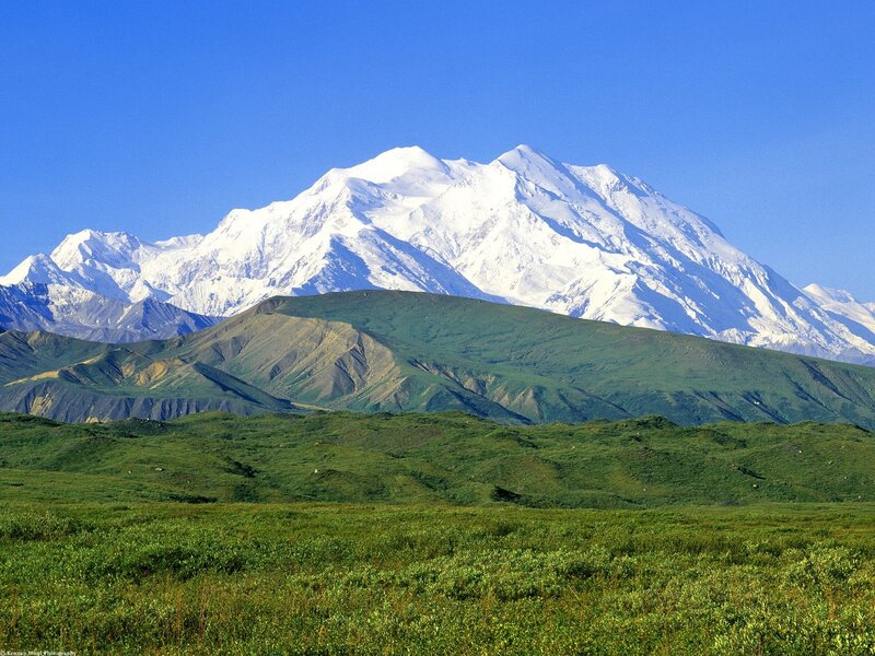 Snow-capped mountain in green valley