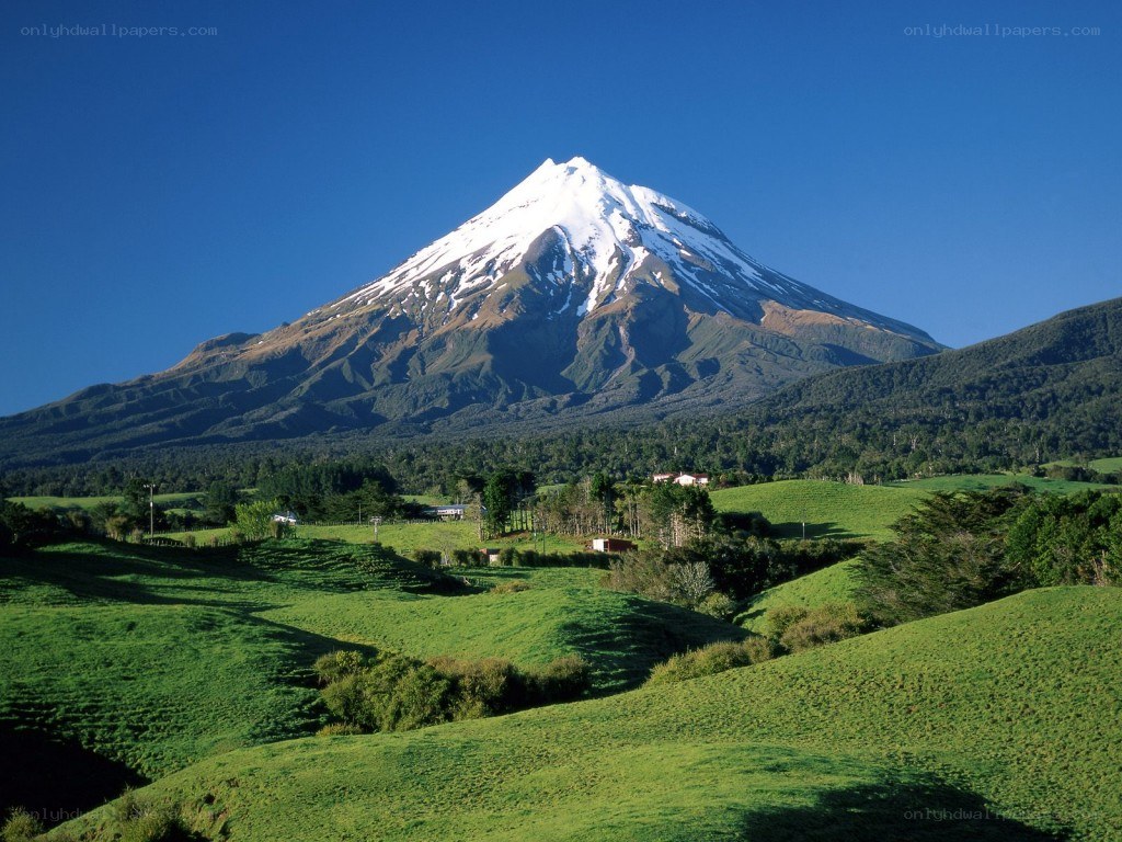 Snow-capped mountain in green valley