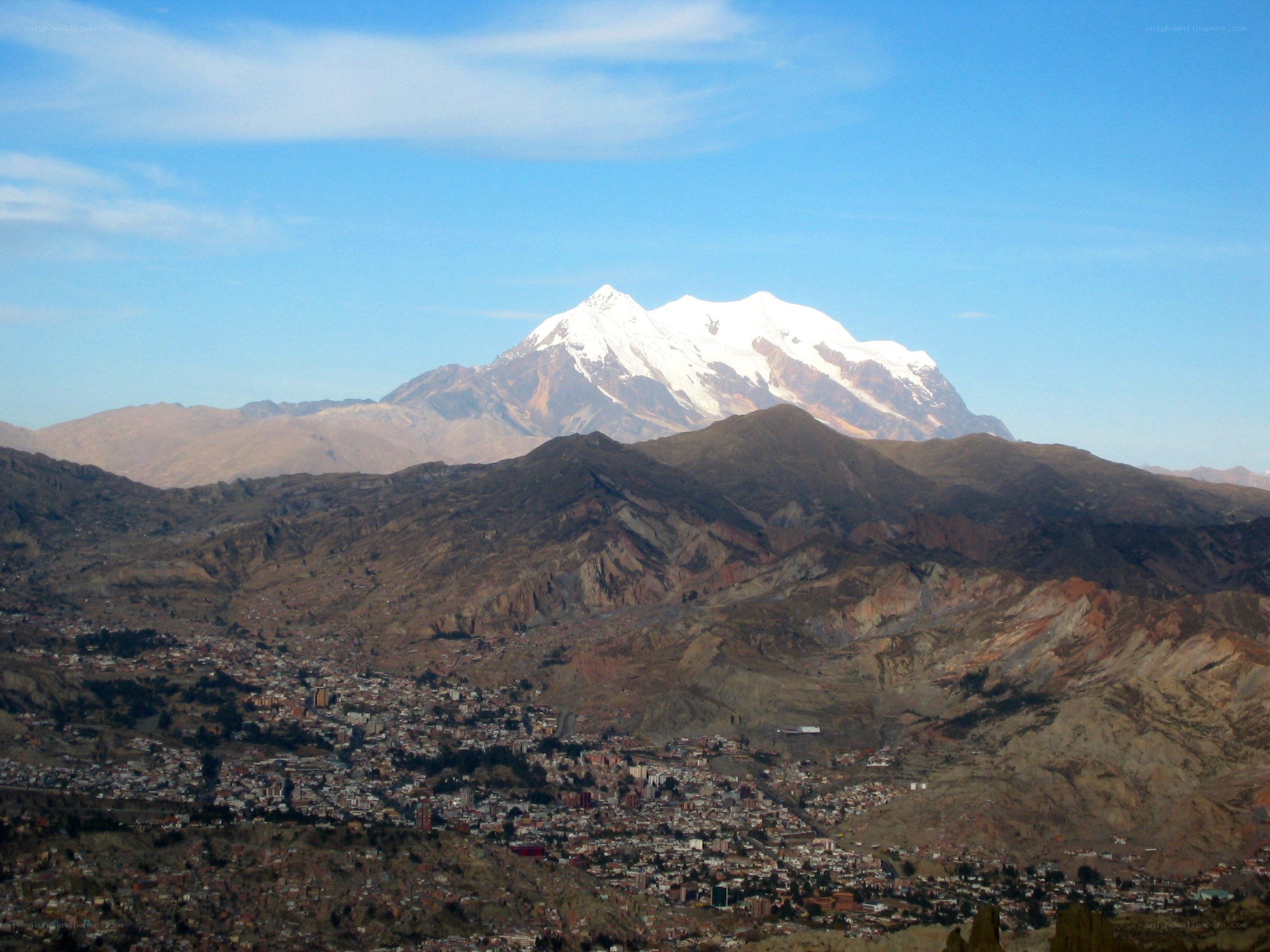 Snow-capped mountain overlooking a city