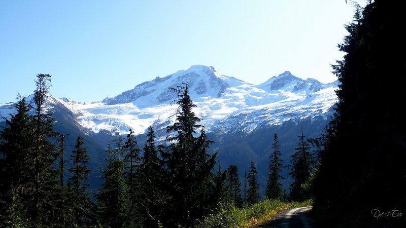 Snow-capped Mountain Peak — Blue, Serene, Afternoon, Photograph, Trees, Road