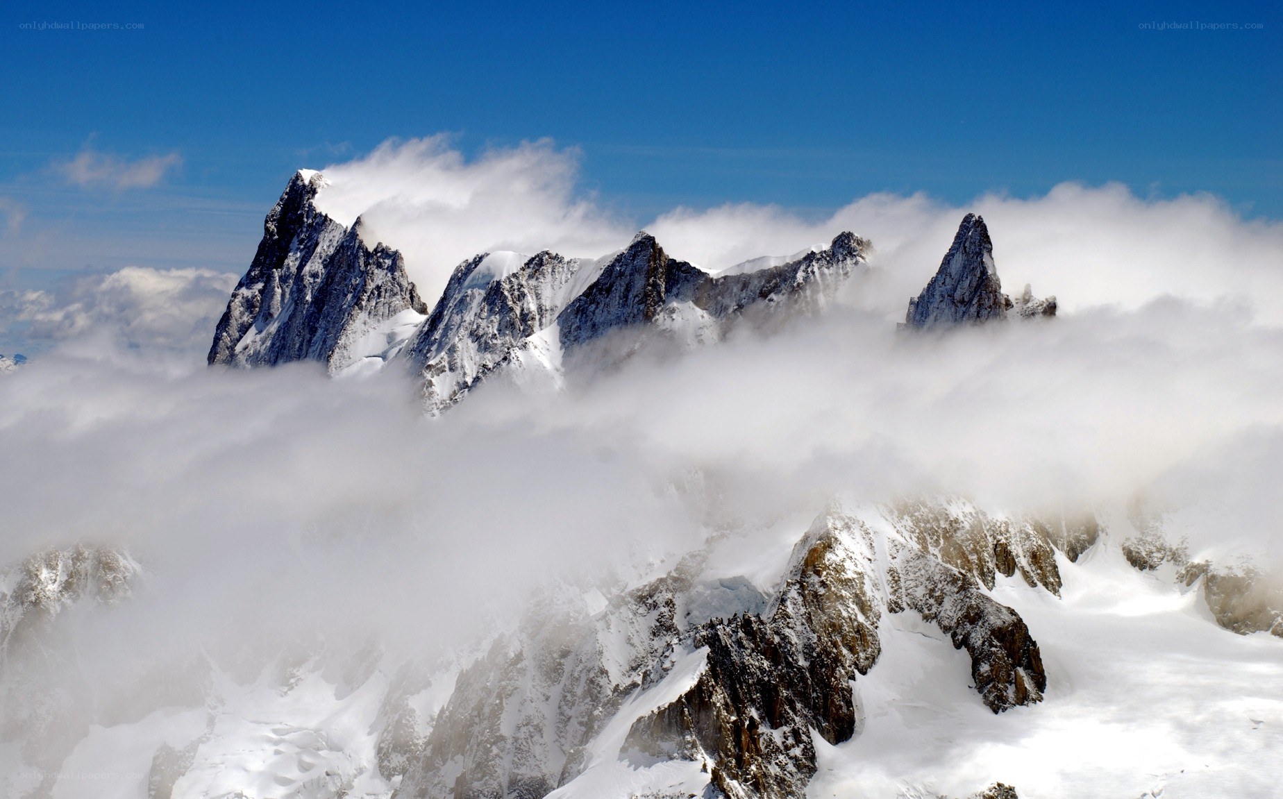 Snow-capped mountain peaks above clouds