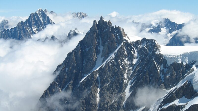 Snow-capped mountain peaks above clouds
