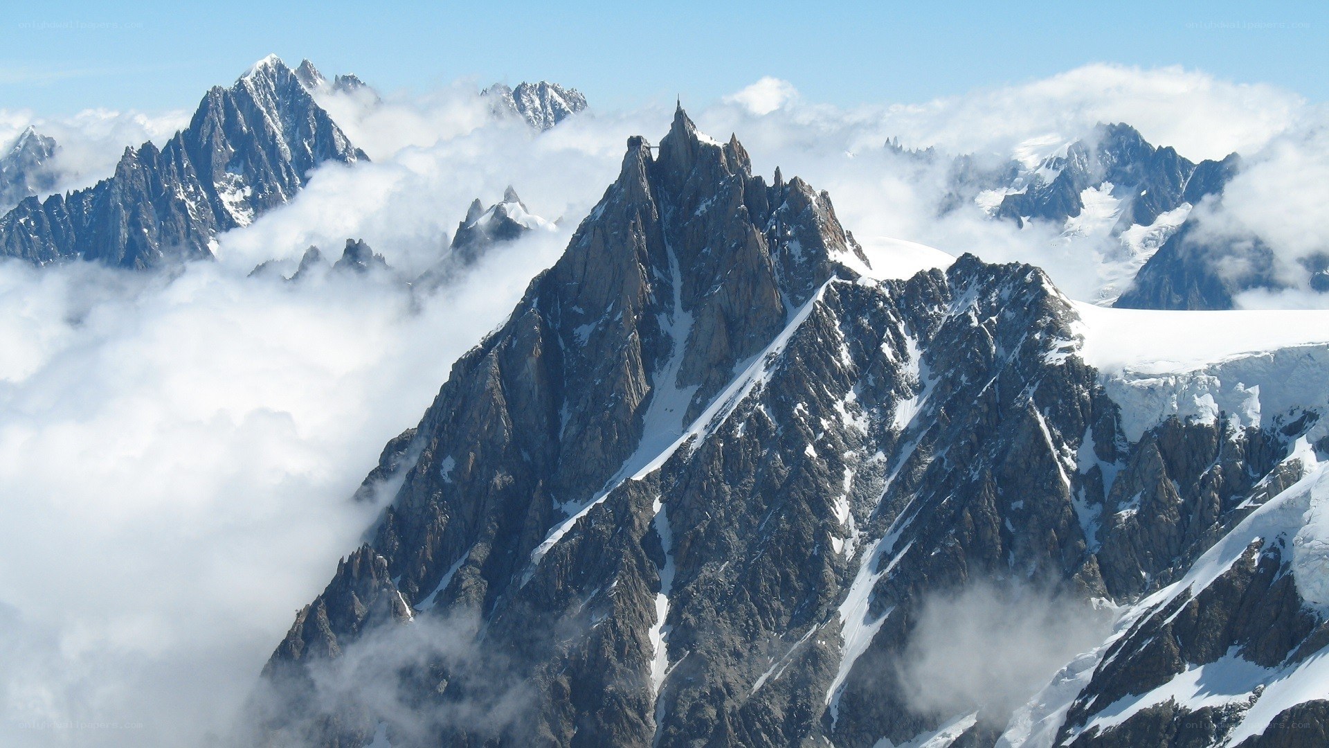 Snow-capped mountain peaks above clouds
