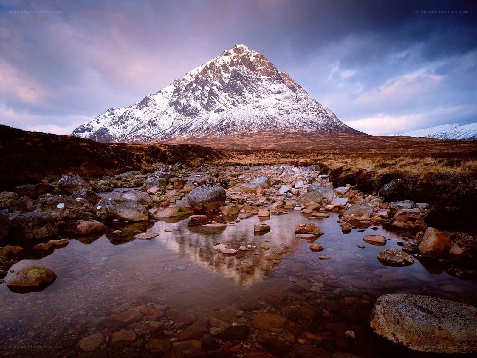 Snow-capped mountain reflected in stream