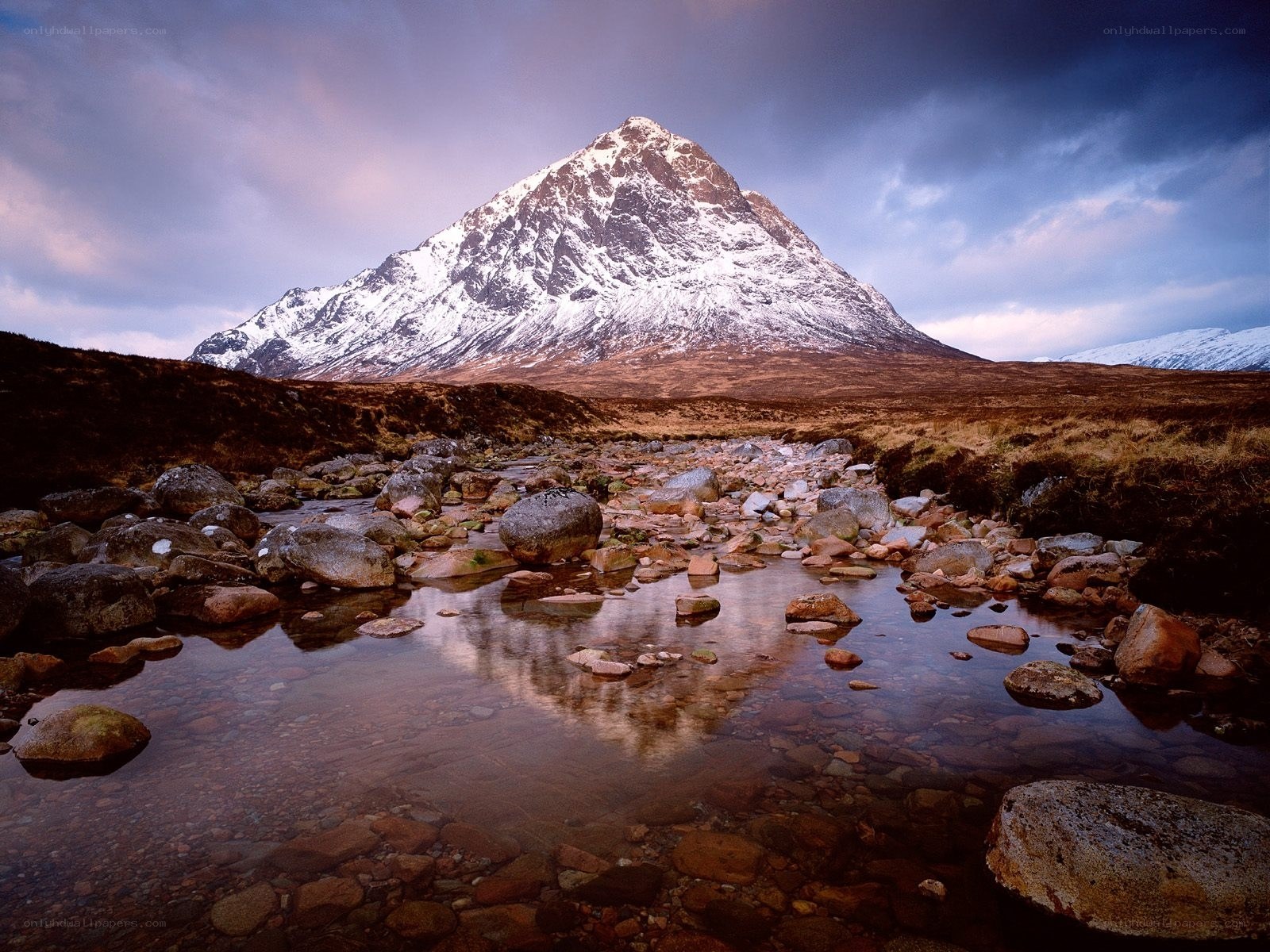 Snow-capped mountain reflected in stream