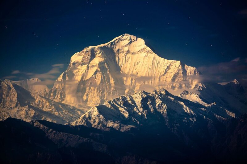 Snow-capped mountain under starry sky