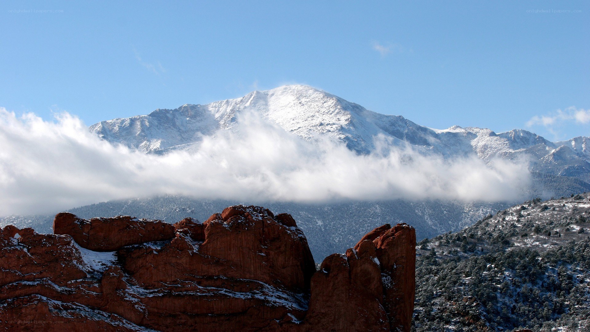 snow-capped mountain with red rocks