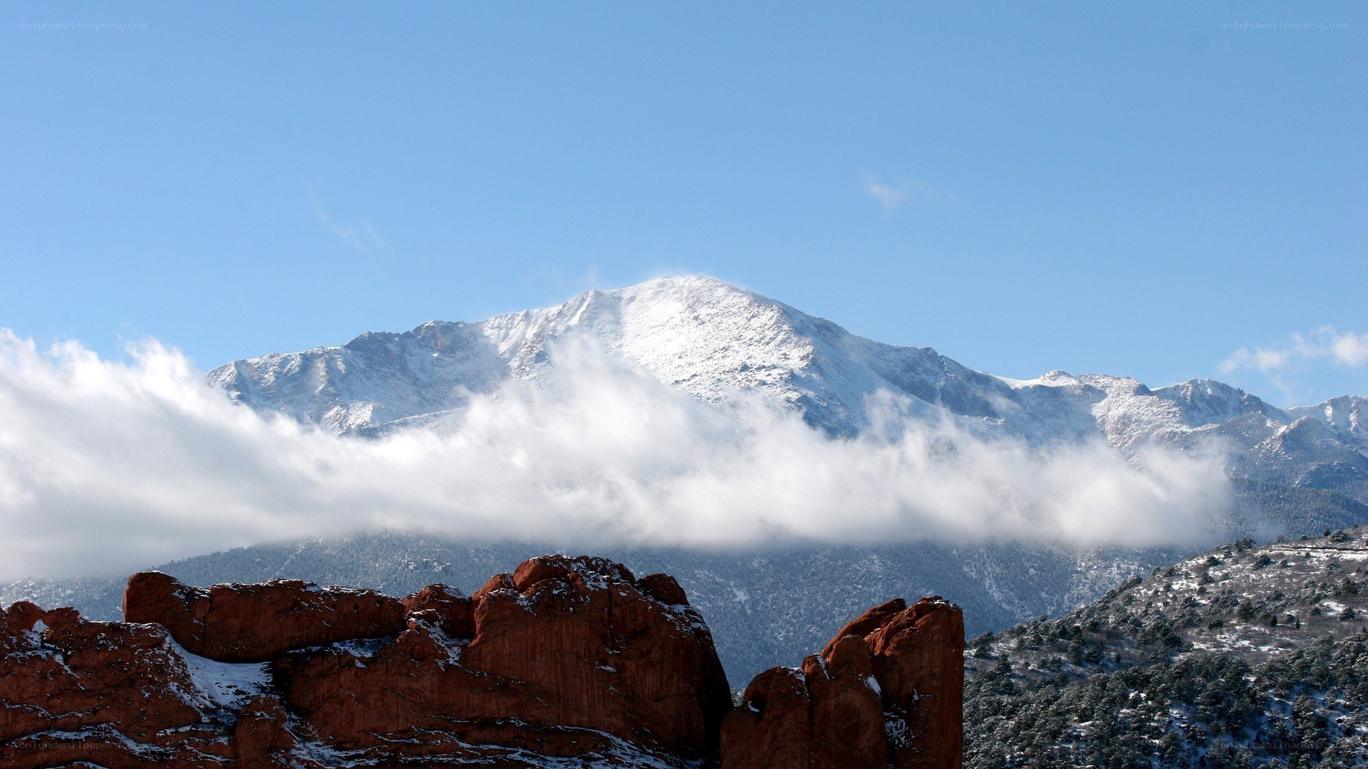 snow-capped mountain with red rocks