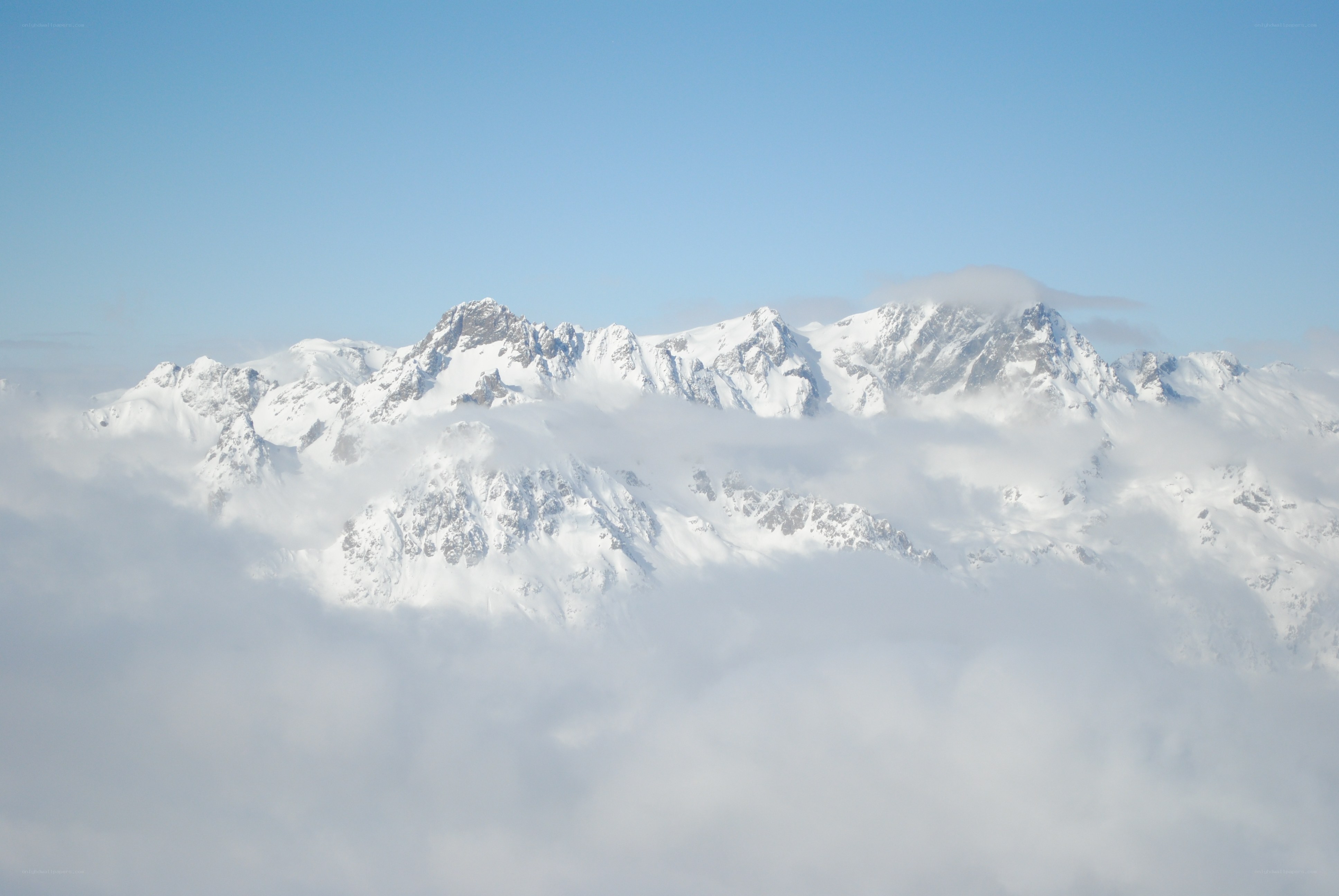 Snow-capped mountains above clouds
