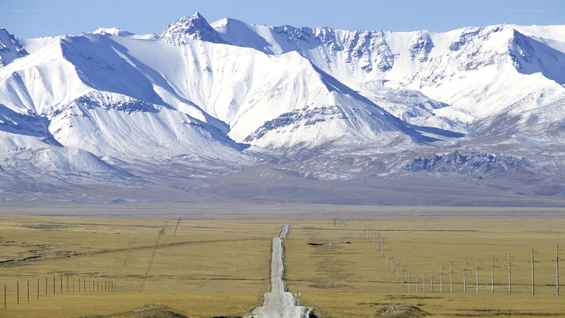Snow-capped mountains and a long road