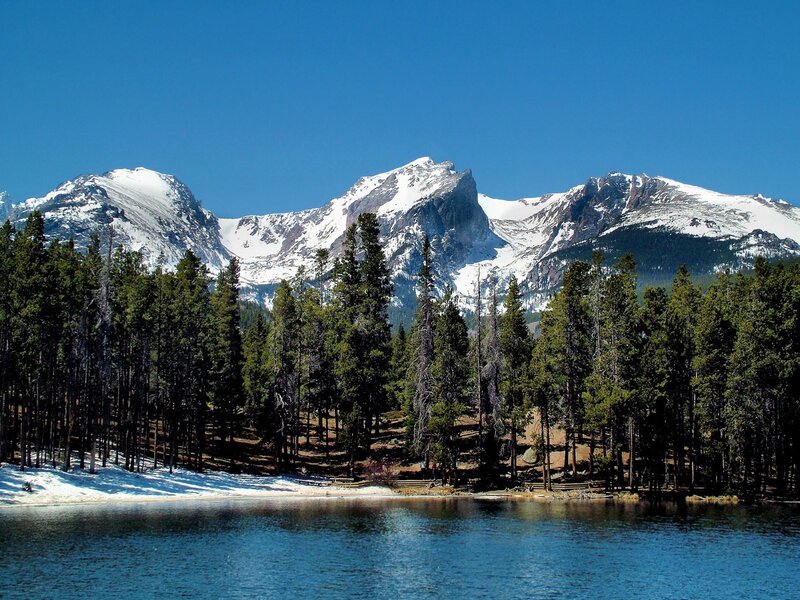 Snow-capped mountains and forest lake