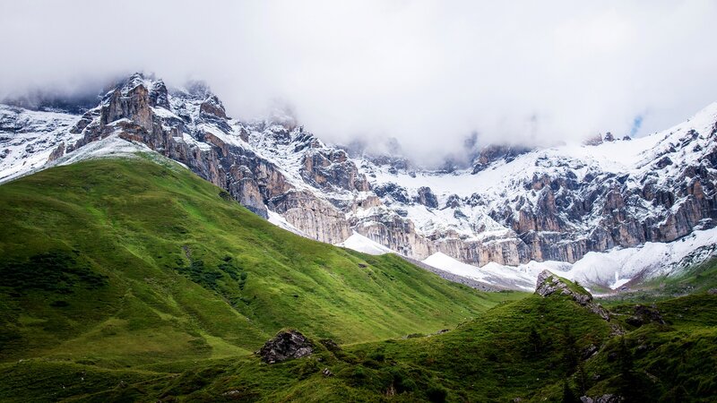 Snow-capped mountains and green hills