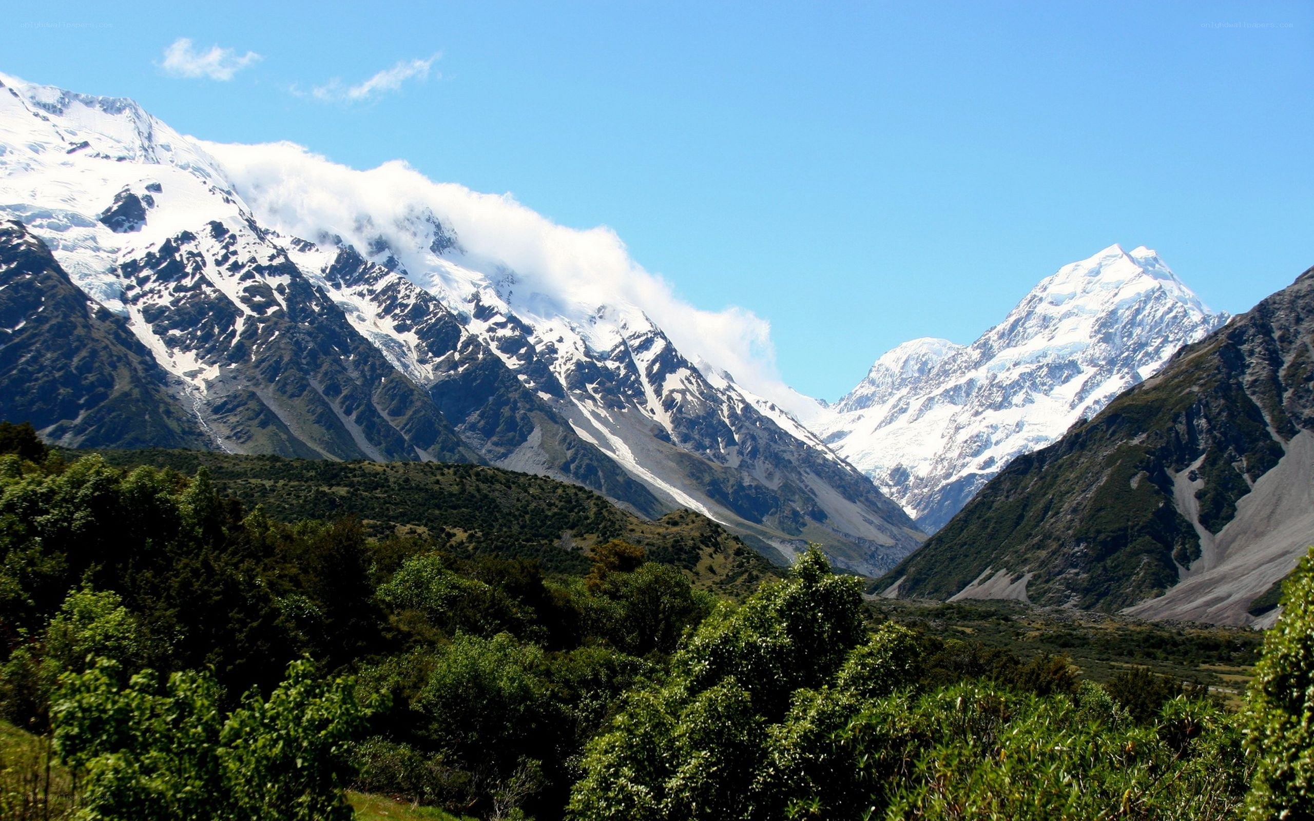 Snow-capped mountains and green valley