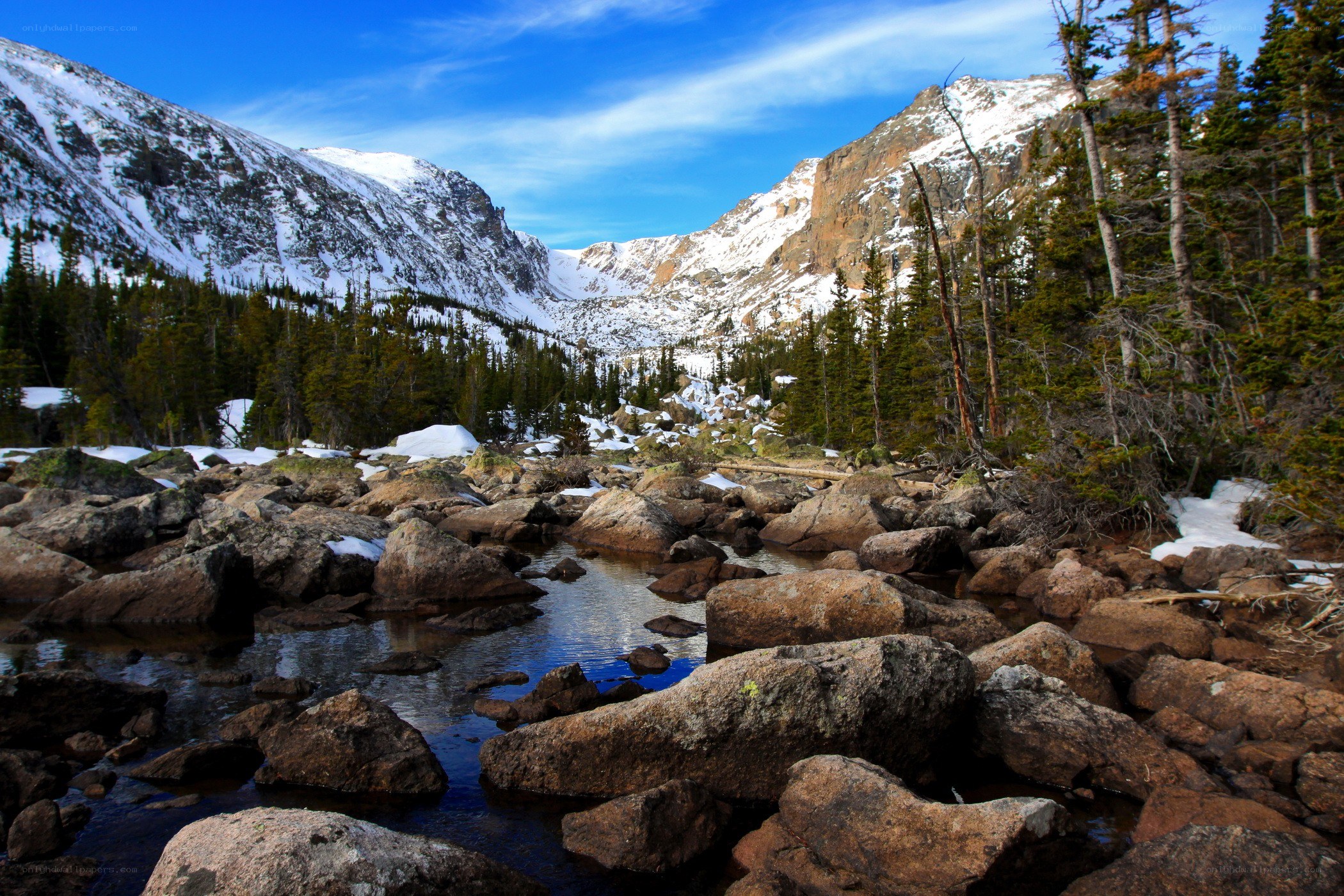 snow-capped mountains and rocky stream