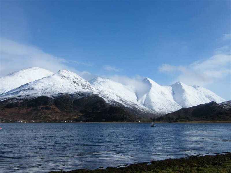 snow-capped mountains by a loch