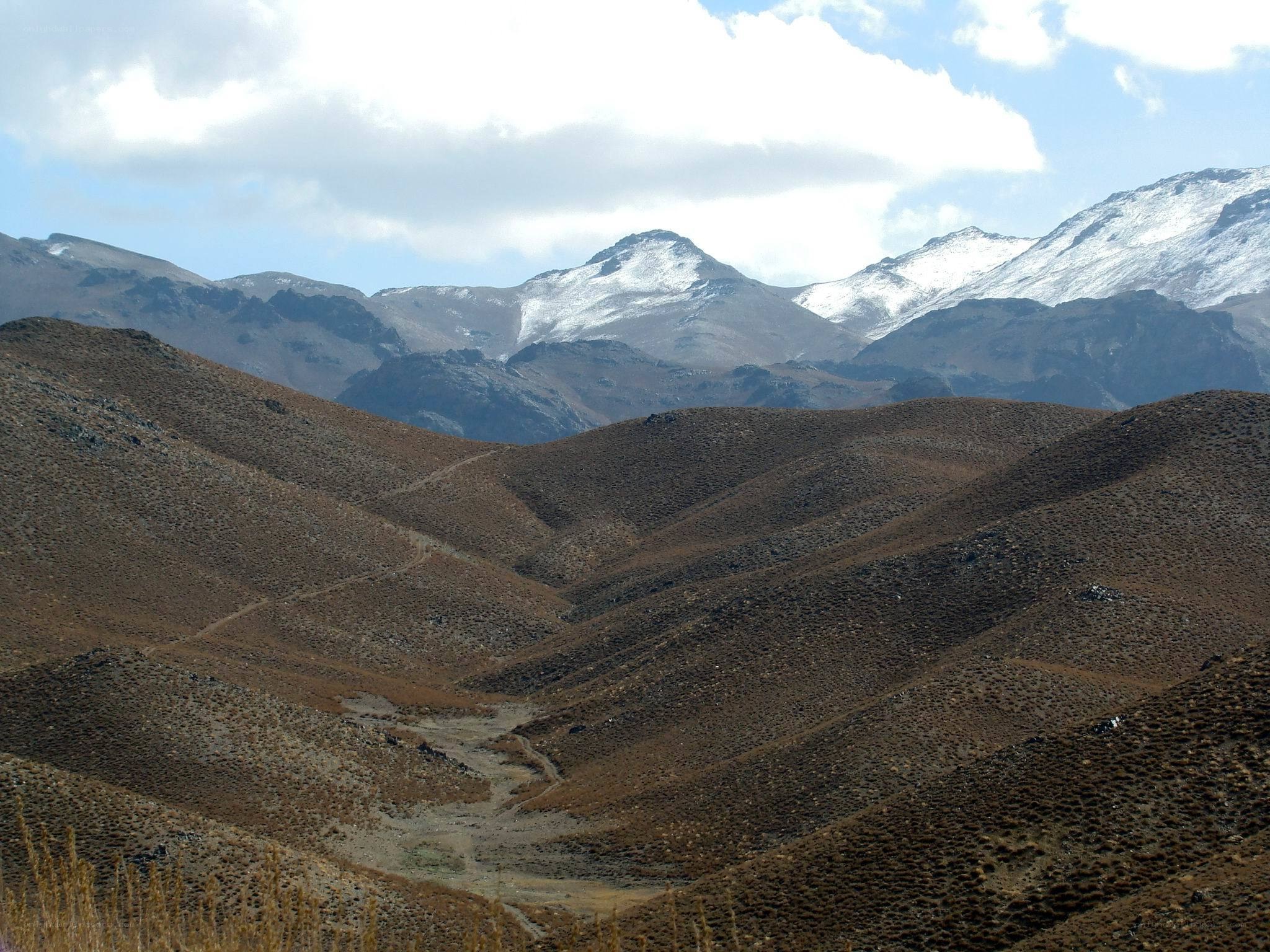 Snow-capped mountains in arid valley