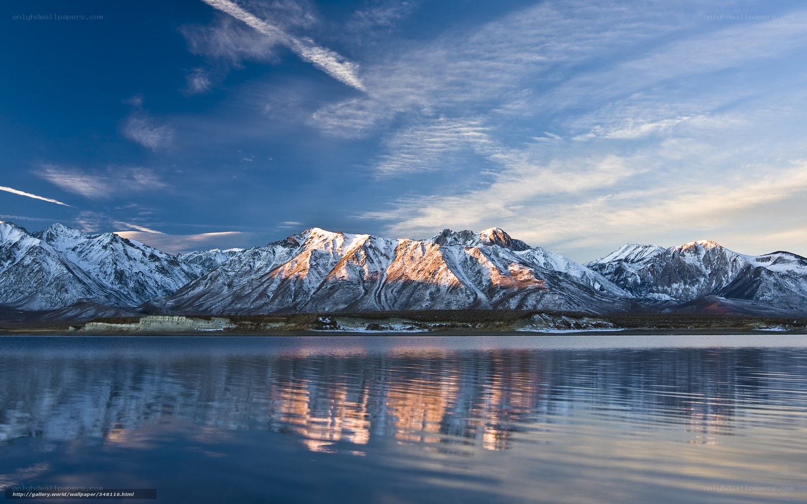 Snow-capped mountains reflect in lake