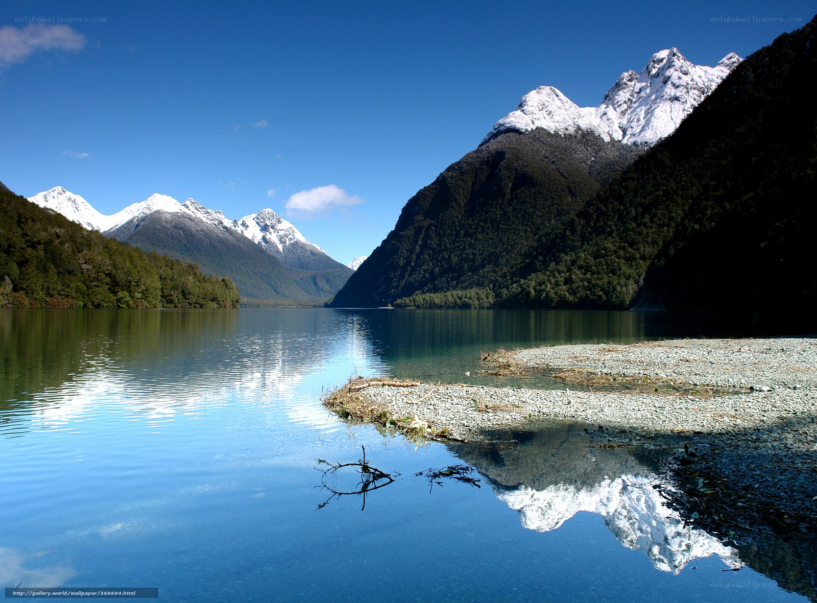 Snow-capped mountains reflect in lake